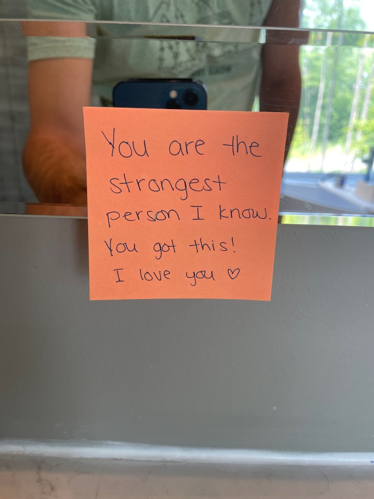 Sticky note on bathroom mirror that reads "You are the strongest person I know. You got this! I love you".